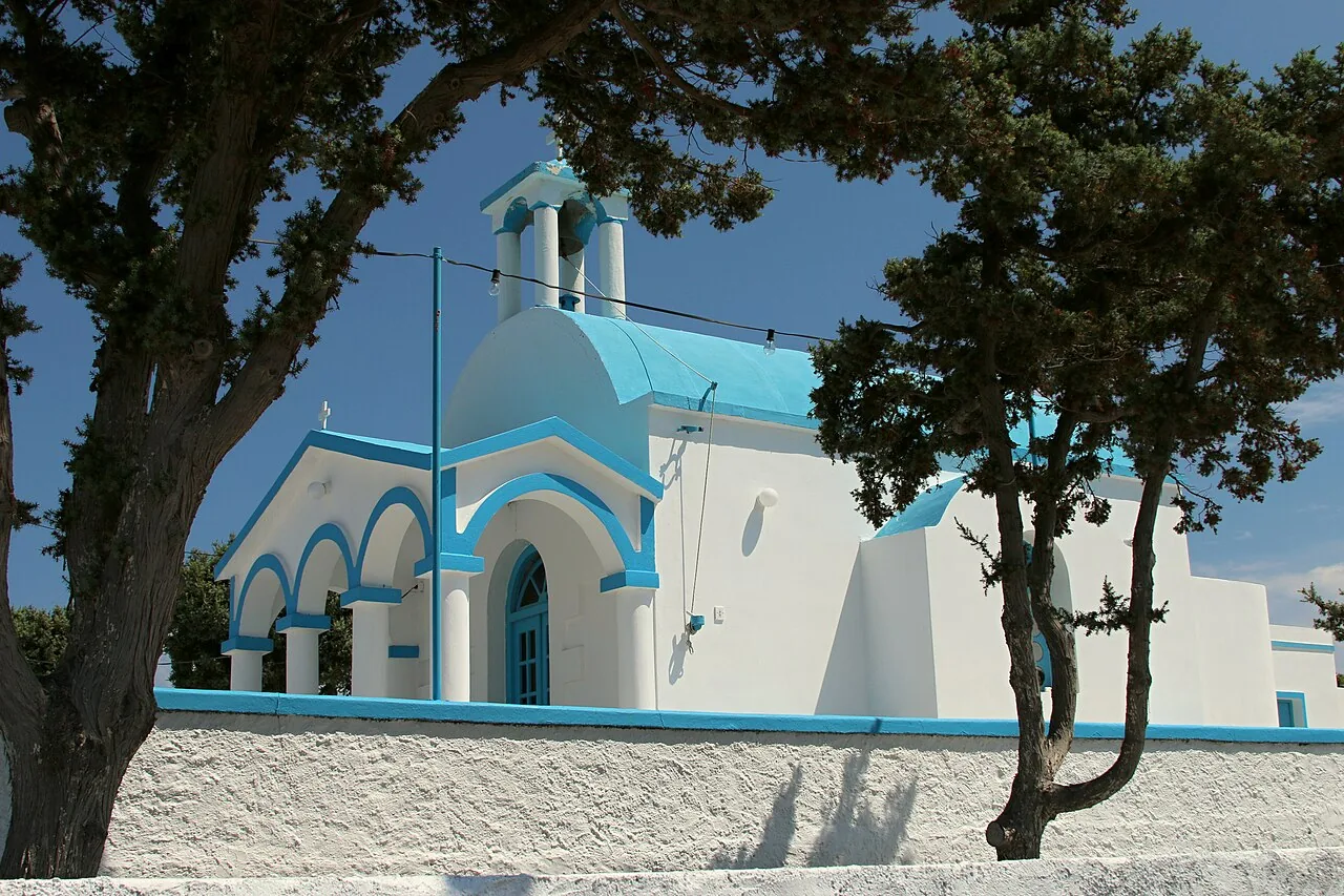 Agios Nikolaos church at Pollonia with a blue dome under tamarisk trees