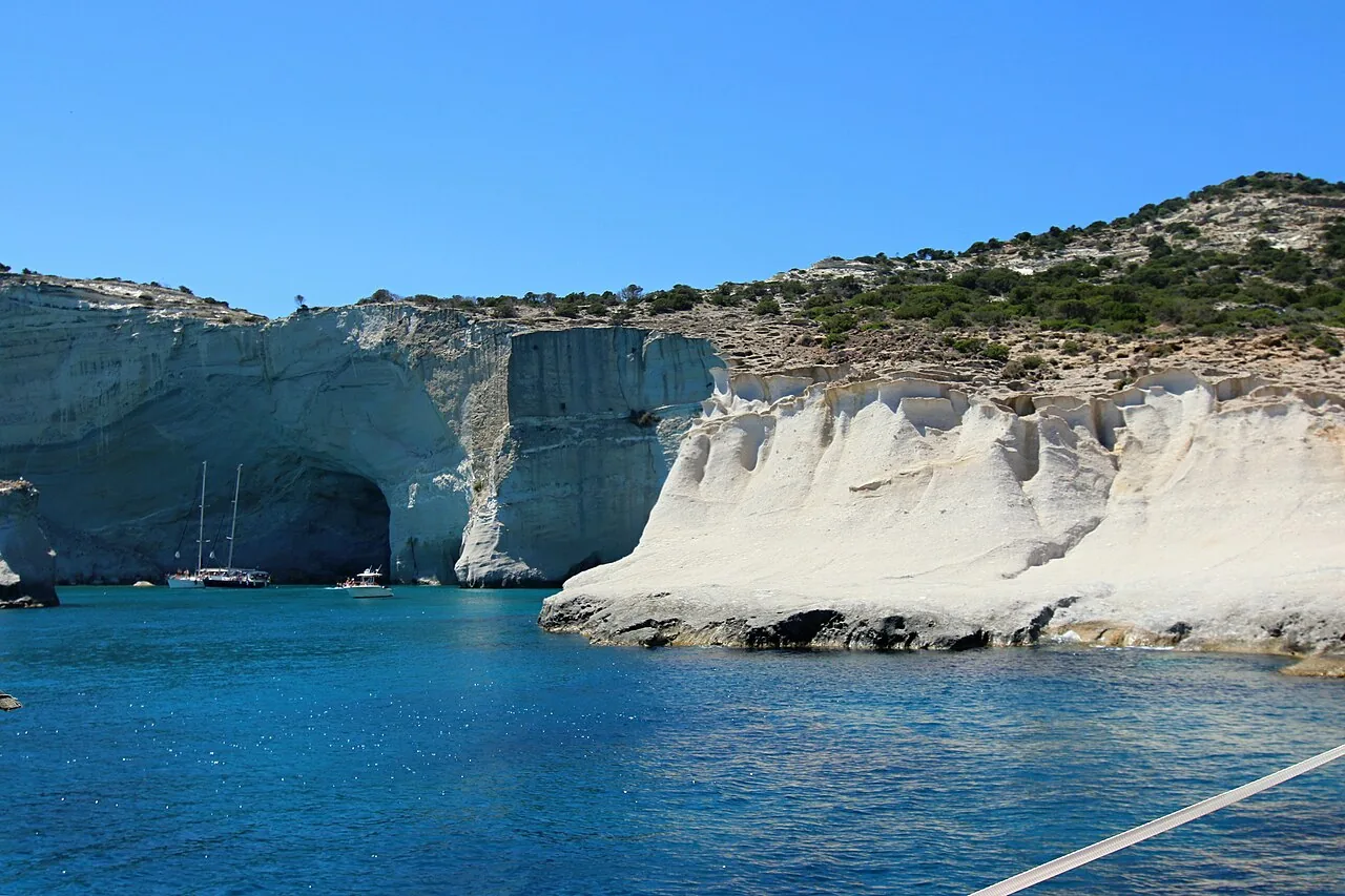 Kleftiko: white sea cliffs and caves with boats moored in blue water