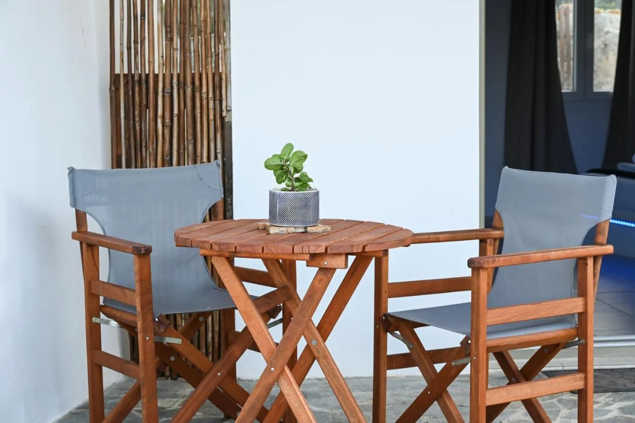 Two folding wooden chairs and a small table on the studio's terrace